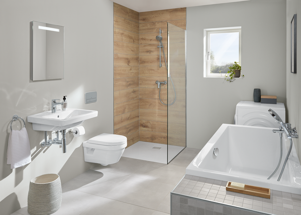 Modernes Badezimmer mit bodengleicher Dusche, Badewanne und wandhängender Toilette. Helle Fliesen, Holzoptik und minimalistische Einrichtung sorgen für ein stilvolles Design.